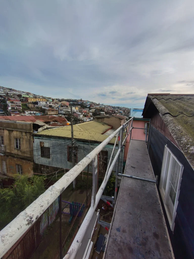 Pasillo de andamio en altura con vista a los cerros de Valparaíso